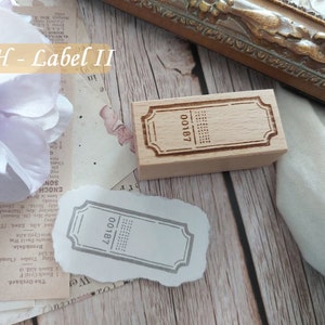 May include: Two wooden stamps with a rectangular shape and a decorative border. The stamps have the text "00187" printed on them. The stamps are on a white surface.