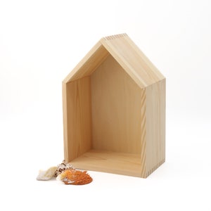 Può includere: Un ripiano in legno a forma di casa con finitura in legno naturale. Il ripiano è vuoto e pronto per essere decorato.