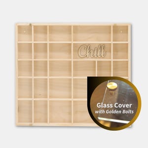 May include: A wooden display case with multiple square compartments. The word "Chill" is cut out and placed on the top right. A circular inset shows a glass cover with golden bolts.