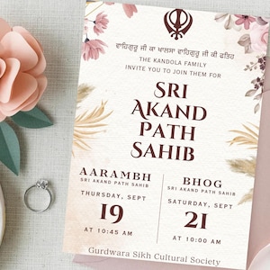 Pode incluir: Um convite para uma cerimónia Sri Akand Path Sahib. O design apresenta detalhes florais, texto em inglês e punjabi e detalhes do evento. Uma grande flor de papel e um anel estão em primeiro plano.