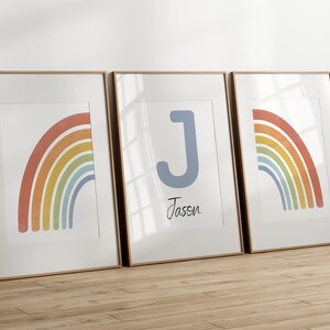 May include: Three framed prints with a rainbow design. The middle print features the letter J and the name Jassen.