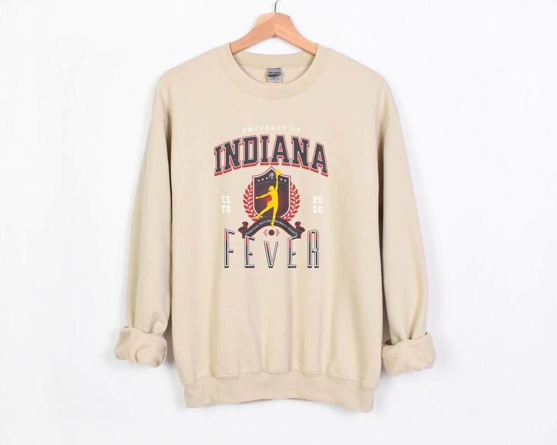 May include: A beige sweatshirt with a graphic print of a basketball player and the text "Property of Indiana Fever Est. '78 '80".