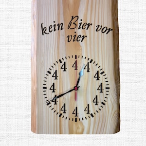 Può includere: Orologio in legno con la scritta "kein Bier vor vier" e un quadrante con il numero 4. Le lancette sono nere, con una lancetta dei secondi rossa e una punta blu sulla lancetta delle ore. L'orologio è in legno chiaro.