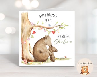 Może przedstawiać: Aquarela przedstawiająca dwa niedźwiedzie tulące się pod drzewem z kolorowymi girlandami. Tekst brzmi: "Happy Birthday Daddy, Love you lots, Charlie x". Kartka jest od Lola, Fox & Bear.