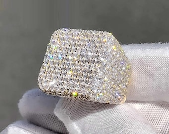 May include: A gold ring with a square face covered in small, clear stones.