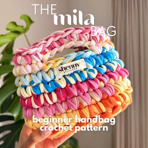 Könnte beinhalten: Eine mehrfarbige gehäkelte Handtasche mit geflochtenem Henkel. Die Tasche zeigt Schichten aus Rosa, Gelb, Blau und Orange. Der Text "THE mila BAG" und "beginner handbag crochet pattern" sind sichtbar. Ein Etikett trägt die Aufschrift "shenny STITCHES".