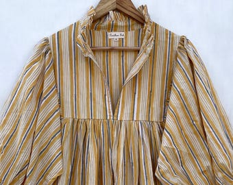 May include: A yellow and white striped dress with a ruffled collar and puffed sleeves. The dress has a gathered waist and a flowing skirt.