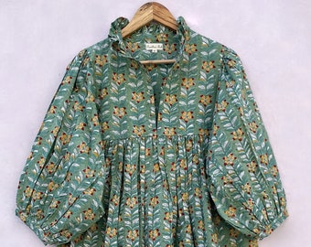 May include: A green floral print dress with a ruffled collar and long sleeves. The dress has a gathered waist and a flowing skirt.