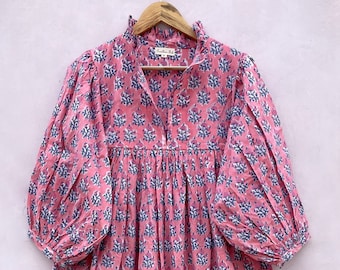 May include: A pink and blue floral print cotton dress with a ruffled collar and long, puffed sleeves. The dress has a gathered waist and a flowing skirt.
