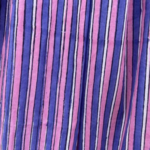 May include: Close-up of a fabric with vertical stripes in pink, blue, and white.