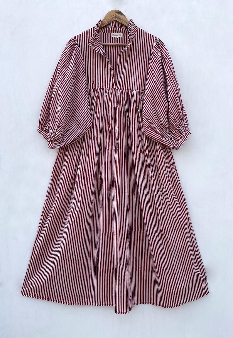 May include: A red and white striped dress with a ruffled collar and puffed sleeves. The dress has a gathered waist and a midi length.