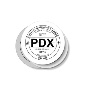 May include: A white round sticker with black text and a black airplane symbol. The sticker says "Portland International Airport", "45.5898 N. 122.5951 W", "Elevation 30 FT", "PDX", "10L/28R 10R/28L 3/21", "KPDX", "Portland, OR", and "Est 1936".