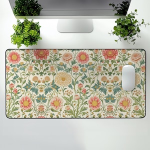 May include: A floral patterned mouse pad with a white background and pink, yellow, and green flowers. The mouse pad has a black border.
