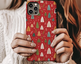 May include: A red phone case with a repeating pattern of colorful Christmas trees and white dots. The trees are in shades of green, yellow, and white. The case has a camera cutout and is held in front of a person.