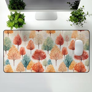 May include: A mouse pad with a watercolor pattern of colorful trees on a white background. The trees are in shades of red, orange, yellow, green, and blue.