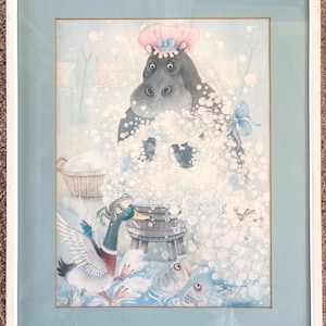 May include: Framed watercolor print featuring a hippo in a pink bonnet taking a bath in a sea of bubbles. A duck, frogs, and fish are also present. The artwork is framed in a white frame with a light blue mat.