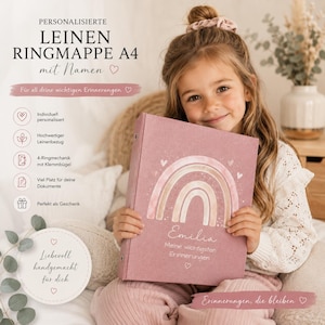May include: A dusty rose A4 linen ring binder featuring a printed rainbow graphic, the name Emilia, and the text Meine wichtigsten Erinnerungen. The binder includes a 4-ring mechanism with a clamp, designed for document storage and organisation.