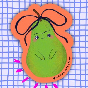 Puede incluir: Una pegatina verde con forma de pera con una cara linda, un lazo negro y un borde naranja. La pegatina tiene el texto "@ELECTRO CUTE STUDIO" y está colocada sobre un fondo de cuadrícula azul y blanca. Estallidos de estrellas rosas emanan de la parte inferior.