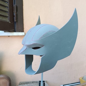 May include: A gray foam helmet with a pointed nose and large ears. The helmet has lines drawn on it, possibly for cutting or shaping.