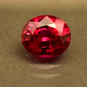 Peut inclure: Une pierre précieuse rouge foncé avec une taille facetée. La pierre précieuse est ronde et a un haut poli.