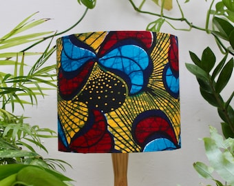 May include: A lampshade with a colorful abstract pattern in shades of red, yellow, blue, and black. The pattern features geometric shapes and lines.