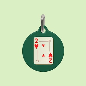 May include: A green round tag with a silver ring. The tag features a white playing card with a red two of hearts.