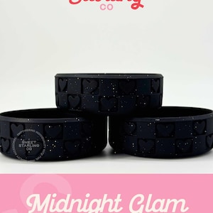 May include: Three black silicone rings with heart-shaped cutouts and glitter. The rings are stacked on top of each other. The text "Sweet Starling Co" is at the top, and "Midnight Glam Pixie" is at the bottom.