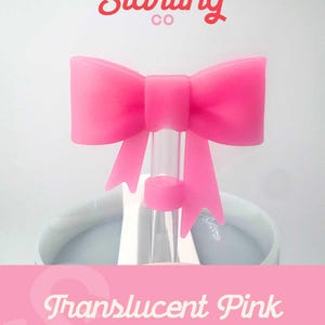 May include: Translucent pink silicone bow straw topper.  The bow is attached to a clear glass straw.