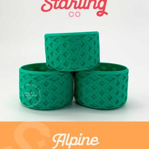 May include: Three green silicone can koozies stacked on top of each other. The koozies have a diamond pattern. The logo "Sweet Starling Co." is in pink and red at the top of the image. The text "Alpine SSC Signature" is in white on an orange background at the bottom of the image.