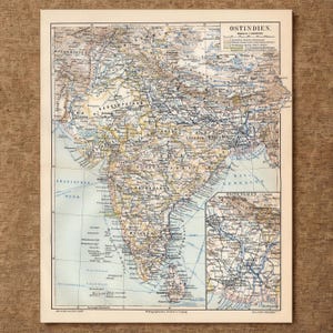 Puede incluir: Un mapa de papel de estilo antiguo titulado OSTINDIEN, que representa el subcontinente indio con topografía detallada, fronteras políticas y líneas ferroviarias. Un mapa insertado más pequeño de Bengala Oriental aparece en la esquina inferior derecha.