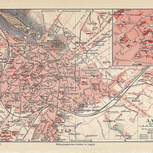 Może przedstawiać: Antyczna mapa Akwizgranu w Niemczech, z czerwonymi oznaczeniami wskazującymi różne dzielnice. Mapa przedstawia układ miasta, w tym ulice, parki i drogi wodne. Tytuł "AACHEN" jest wydrukowany pogrubioną czcionką w prawym dolnym rogu, wraz z skalą i kluczem.