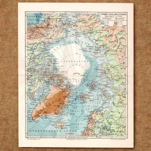 May include: A vintage-style paper map titled Nord-Polarlander depicting the Arctic region. The map features light blue oceans, tan landmasses, and white ice-covered areas around the North Pole, with detailed German text labels and a legend.
