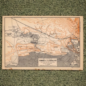 May include: A vintage-style printed map titled So called TOMBS of the KHALIFS to the E. of Cairo, chiefly by Franz-Bey. The map features beige and grey tones, displaying topographical lines, railway paths, and labeled landmarks in English.