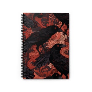 May include: A spiral bound notebook with a red and black design featuring a repeating pattern of crows and ornate floral details.