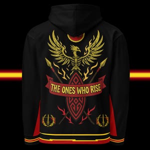 May include: Black hoodie with a gold phoenix design, spears, and the text "THE ONES WHO RISE." The design includes a red banner and accents. The hoodie has red and yellow trim.