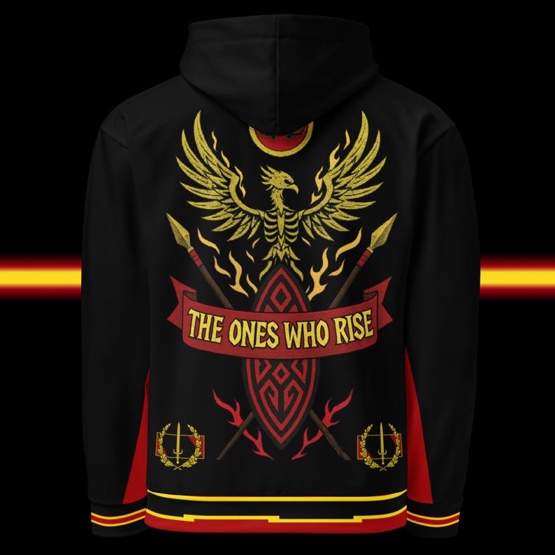 May include: Black hoodie with a gold phoenix design, spears, and the text "THE ONES WHO RISE." The design includes a red banner and accents. The hoodie has red and yellow trim.