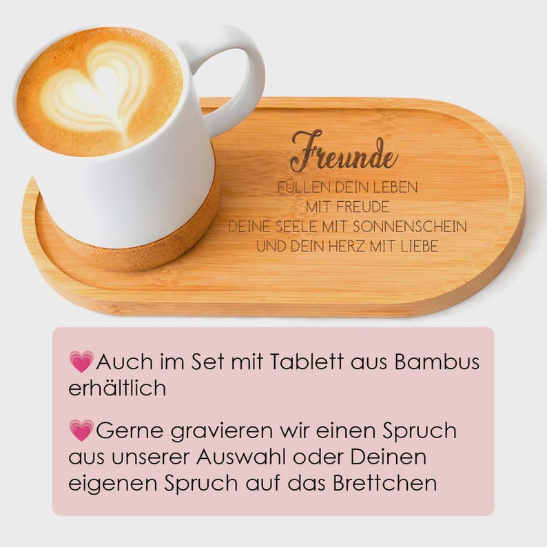 May include: A white ceramic mug with a cork base containing coffee with heart-shaped latte art, resting on an oval bamboo tray engraved with the German text: Freunde, f&uuml;llen dein Leben mit Freude, deine Seele mit Sonnenschein und dein Herz mit Liebe.