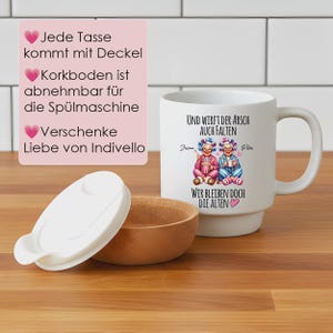 May include: A white ceramic mug with a handle, featuring a graphic of two elderly characters in pajamas and hair rollers, with the German text "Und wirft der Arsch auch Falten, wir bleiben doch die Alten". Includes a white lid and a removable cork base.