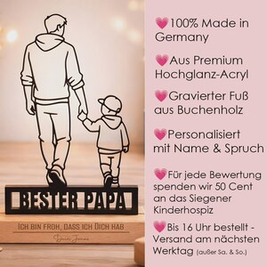 May include: A black acrylic silhouette of an adult and a child holding hands, mounted on a wooden base. The base features the engraved text "BESTER PAPA" and "ICH BIN FROH, DASS ICH DICH HAB" with the name "Dein Jonas" below the phrase.