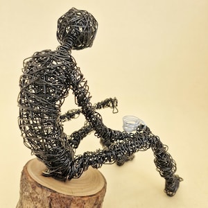 Draadsculptuur van een man met een kopje koffie