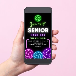 May include: A smartphone displaying a digital invitation for a senior game day. The invitation features neon green, pink, and blue volleyball graphics and the text "Join us for Senior Game Day, Team A vs. Team B. Friday, September 22 at 6:30 PM, Home Gymnasium, Wear red to cheer on your seniors!"