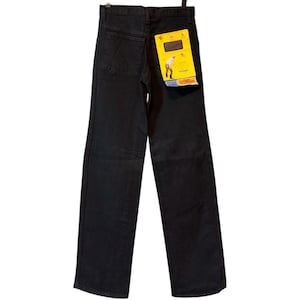 K&ouml;nnte beinhalten: Schwarze Jeans aus Denim mit geradem Bein. Die Jeans haben ein klassisches F&uuml;nf-Taschen-Design und ein gelbes Etikett an der Ges&auml;&szlig;tasche. Das Etikett zeigt eine Grafik und den Markennamen.