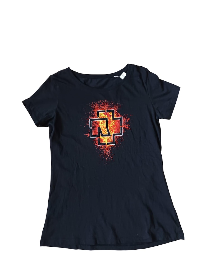 May include: Black crew neck t-shirt featuring a red and orange graphic design. The graphic is a stylized cross with the letter "N" inside, set against a fiery background. The shirt is made of a soft material.