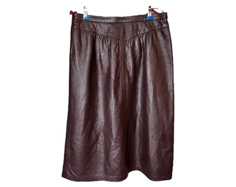 May include: A brown leather skirt with a straight cut and a slight A-line shape.