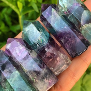 May include: Five green, purple and blue fluorite crystal points. The points are smooth and polished, with a variety of colours and patterns.