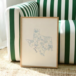 Design the ultimate aesthetic teen girl bedroom by styling this personalized college dorm wall art set of three. This blue preppy digital download features a custom university poster, a classic floral initial, and an elegant state map print. Seamlessly matching the highly trending grandmillennial and coastal granddaughter interior design aesthetics. This printable graduation gift delivers immense emotional utility, providing a bright and uniquely customized personality to any modern apartment.
