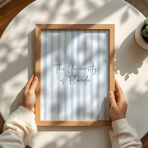 Discover the perfect meaningful alumni gift with this sophisticated blue preppy gallery wall set of three digital download. Showcasing a customized university poster, a beautiful floral initial monogram, and a detailed state map outline. Ideal for styling a professional home office or a cozy neutral living room. This printable personalized wall art delivers profound emotional utility and a deeply respectful personality, ensuring your interior design beautifully reflects your unique school pride.