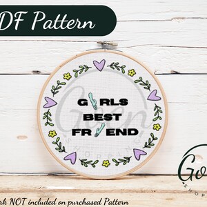 May include: A white embroidery hoop with a floral design and the text "GRLS BEST FR END" in black. The hoop is on a white wooden surface.