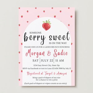 May include: A pink and white baby shower invitation with a strawberry illustration. The text reads "Someone berry sweet is on the way. Please join us for a ladies brunch honouring Morgan & Sadie. Sat July 22, 11 AM. 1234 Easy Street City, State Zip. RSVP via Facebook or text to Luna 123.456.7890 by July 12. Registered at Target & Amazon. Bring a pack of nappies of any size for a chance to win a prize. (Each pack of nappies or wipes counts as an entry)"