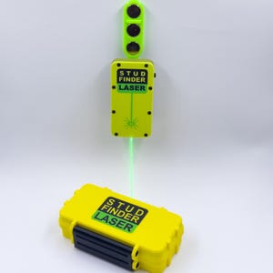 May include: A yellow stud finder laser tool with the text "STUD FINDER LASER" on the front. The tool has a green laser beam and a green light indicator. A yellow case with the same text is at the bottom.